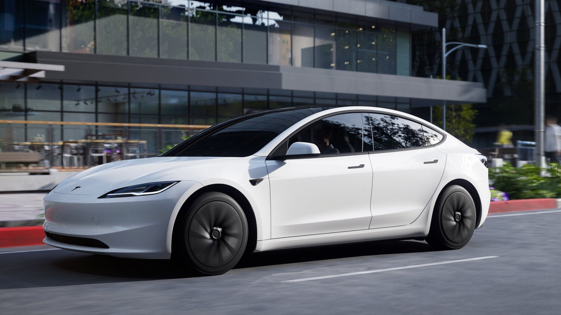 Grafico di andamento azionario in rosso, schermi con dati finanziari, simbolo del titolo Tesla in calo